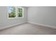Bright bedroom with neutral carpet, white trim, and large window with backyard view at 248 Ashford Dr, Pittsboro, NC 27312