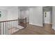 Spacious second floor hallway features hardwood floors, wrought iron railing, and natural light at 248 Ashford Dr, Pittsboro, NC 27312
