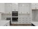 Kitchen with white cabinets, stainless steel appliances including double oven, and a wine cooler at 248 Ashford Dr, Pittsboro, NC 27312