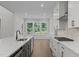 Open kitchen with island sink, stainless steel appliances, and large windows viewing lush backyard at 248 Ashford Dr, Pittsboro, NC 27312
