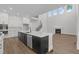 Modern kitchen with an island sink, stainless steel appliances, and open floorplan with fireplace at 248 Ashford Dr, Pittsboro, NC 27312