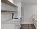 Close-up of kitchenette, featuring white cabinets, marble countertop, stainless steel dishwasher and matte black faucet at 248 Ashford Dr, Pittsboro, NC 27312