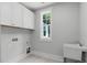 Bright laundry room with white cabinets, a window for natural light, and a utility sink at 248 Ashford Dr, Pittsboro, NC 27312
