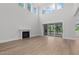 Spacious living room with a cozy fireplace, large windows, and sliding glass doors at 248 Ashford Dr, Pittsboro, NC 27312