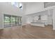 Open-concept living room with fireplace, tall windows, screened porch access, and kitchen view at 248 Ashford Dr, Pittsboro, NC 27312