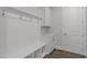 Bright mudroom with white cabinets, built-in bench, coat hooks, and luxury vinyl plank flooring at 248 Ashford Dr, Pittsboro, NC 27312