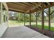 Covered patio with concrete flooring supported by wood pillars with backyard view and tree coverage at 248 Ashford Dr, Pittsboro, NC 27312