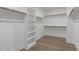 Spacious walk-in closet with built-in shelving, hanging rods, and wood grain flooring at 248 Ashford Dr, Pittsboro, NC 27312