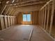 Unfinished attic space with exposed wood framing and a large window at 253 Inspiration Way, Fuquay Varina, NC 27526