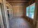 Unfinished bedroom with exposed framing and large window overlooking the property at 253 Inspiration Way, Fuquay Varina, NC 27526