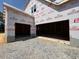 Spacious three car garage featuring ample space for parking and storage in a new home construction project at 253 Inspiration Way, Fuquay Varina, NC 27526