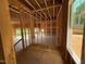 Unfinished living room with exposed framing and view to the exterior in new construction home at 253 Inspiration Way, Fuquay Varina, NC 27526