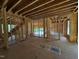 Living room showcasing an open-concept design during framing, with visible wooden structures and natural light at 253 Inspiration Way, Fuquay Varina, NC 27526
