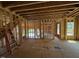 Living room showcasing an open-concept design during framing, with visible wooden structures and natural light at 253 Inspiration Way, Fuquay Varina, NC 27526