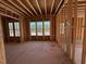 Unfinished living room with exposed framing and a view of the front yard in new construction home at 253 Inspiration Way, Fuquay Varina, NC 27526