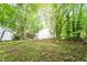 Exterior shot showcasing home's back with a backyard surrounded by lush trees at 2612 Wade Hampton Rd, Hillsborough, NC 27278