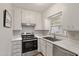 Updated kitchen features stainless steel appliances, white cabinetry, and modern countertops at 2612 Wade Hampton Rd, Hillsborough, NC 27278