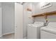 Practical laundry room with washer, dryer, and ample shelving for storage at 2612 Wade Hampton Rd, Hillsborough, NC 27278
