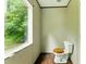 A simple bathroom with a toilet near a window, set against light walls and dark flooring at 2832 Ladale Ln, Mebane, NC 27302