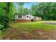 Well-kept single-story home featuring a brick base, traditional siding, and inviting front steps, surrounded by mature trees at 2832 Ladale Ln, Mebane, NC 27302