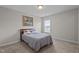 Carpeted bedroom with a queen bed, window, and neutral paint at 30 Sunbury Ct, Zebulon, NC 27597
