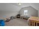 Attic bonus room with a tanning bed, window, hardwood table and wicker chair at 30 Sunbury Ct, Zebulon, NC 27597