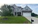 Charming two-story home with stone and siding, lush lawn, and a two-car garage at 30 Sunbury Ct, Zebulon, NC 27597