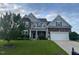 Charming two-story home with stone and siding, lush lawn, and a two-car garage at 30 Sunbury Ct, Zebulon, NC 27597