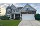 Charming two-story home with stone and siding, lush lawn, and a two-car garage at 30 Sunbury Ct, Zebulon, NC 27597