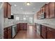 Modern kitchen with stainless steel appliances, dark wood cabinets and island with breakfast bar at 30 Sunbury Ct, Zebulon, NC 27597