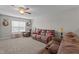 The living room includes comfortable, over-stuffed seating, soft carpet, and a ceiling fan at 30 Sunbury Ct, Zebulon, NC 27597