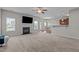 Open concept living room with a fireplace, television, ceiling fan, windows, and a kitchen bar at 30 Sunbury Ct, Zebulon, NC 27597