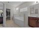 Bright bathroom featuring a built-in tub with an adjacent walk-in closet for ample storage at 30 Sunbury Ct, Zebulon, NC 27597