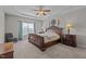 Spacious main bedroom featuring tray ceilings, large windows, and decorative sconces at 30 Sunbury Ct, Zebulon, NC 27597