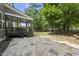 A backyard with a stained patio and a screened-in porch overlooking a wooded area at 300 Redhill Rd, Holly Springs, NC 27540