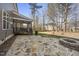 This backyard features a stone patio, a covered porch, and mature trees for outdoor enjoyment at 300 Redhill Rd, Holly Springs, NC 27540