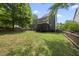 A backyard with a lawn, wooden fence, a stained patio and a screened-in porch at 300 Redhill Rd, Holly Springs, NC 27540