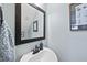 Charming powder room with a framed mirror, artwork, and a stylish faucet at 300 Redhill Rd, Holly Springs, NC 27540