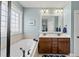 Elegant bathroom featuring a soaking tub, double vanity, and abundant natural light at 300 Redhill Rd, Holly Springs, NC 27540