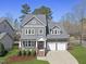 Charming two-story home featuring a two-car garage, manicured lawn, and a welcoming front porch at 300 Redhill Rd, Holly Springs, NC 27540
