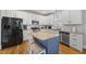 Modern kitchen featuring white cabinetry, stainless steel appliances, and center island with granite countertops at 300 Redhill Rd, Holly Springs, NC 27540