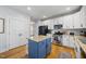 Well-lit kitchen with white cabinets, stainless steel appliances, and a center island with seating at 300 Redhill Rd, Holly Springs, NC 27540