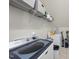 Bright laundry room featuring a white Maytag washer and dryer with wire rack shelving for storage at 300 Redhill Rd, Holly Springs, NC 27540