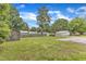 Wide backyard with mature trees and shed, surrounded by a tall wooden fence at 302 Hester St, Knightdale, NC 27545