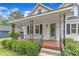 Inviting front porch with decorative iron railings, brick flooring, and lush landscaping at 302 Hester St, Knightdale, NC 27545
