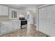 Bright kitchen features white cabinets, stainless steel range, and pantry closet at 302 Hester St, Knightdale, NC 27545