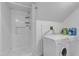 Bright laundry room featuring washer, dryer, shower, and shelving at 302 Hester St, Knightdale, NC 27545