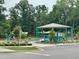 Community playground with a covered play structure, swings, and lush greenery at 302 Hester St, Knightdale, NC 27545
