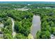 Aerial view shows tree-lined lake with nearby homes and commercial areas at 304 W Kirkfield Dr, Cary, NC 27518