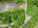 Aerial view of property next to a lake, showcasing mature trees and a nearby road at 304 W Kirkfield Dr, Cary, NC 27518